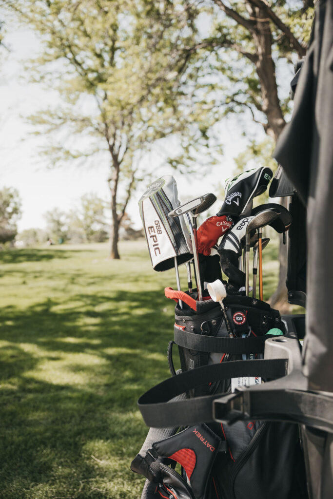Golf clubs strapped into the back of a golf cart